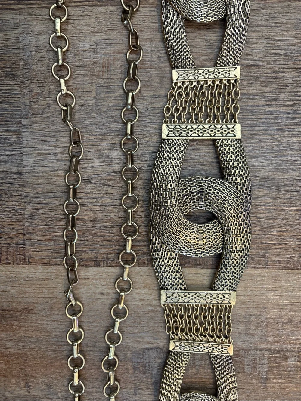 Vingold-tone statement belt featuring textured interlocking links and a chain